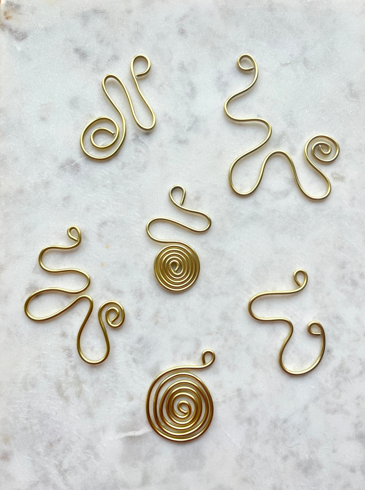 Front billede af alle de tilgængelige vedhæng i forskellige twirl mønster. Vedhængende er guldfarvet