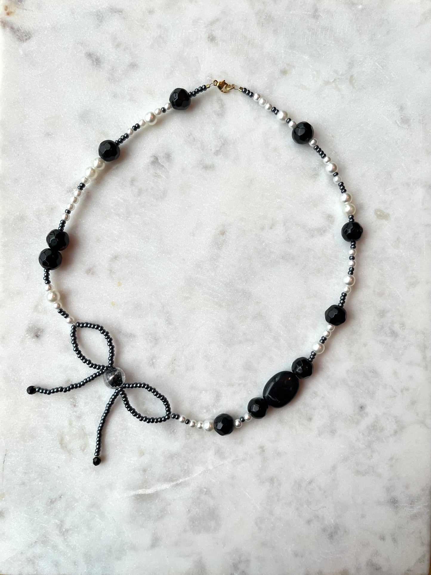 Håndlavet elegant sløjfehalskæde lavet med akrylperler. Front billede 2